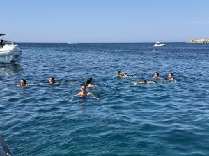Persone che fanno il bagno nelle acque cristalline di Cala Azzurra a Favignana durante il tour Egadi da Marsala
